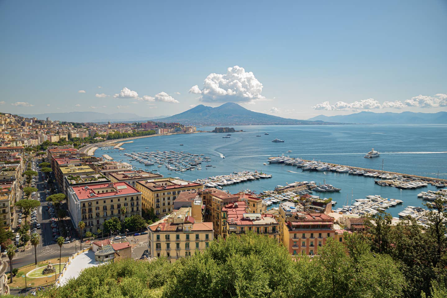 Neapel Urlaub mit DERTOUR. Blick vom Posillipo-Hügel auf Stadt, Jachthafen und den Golf von Neapel mit dem Vesuv am Horizont