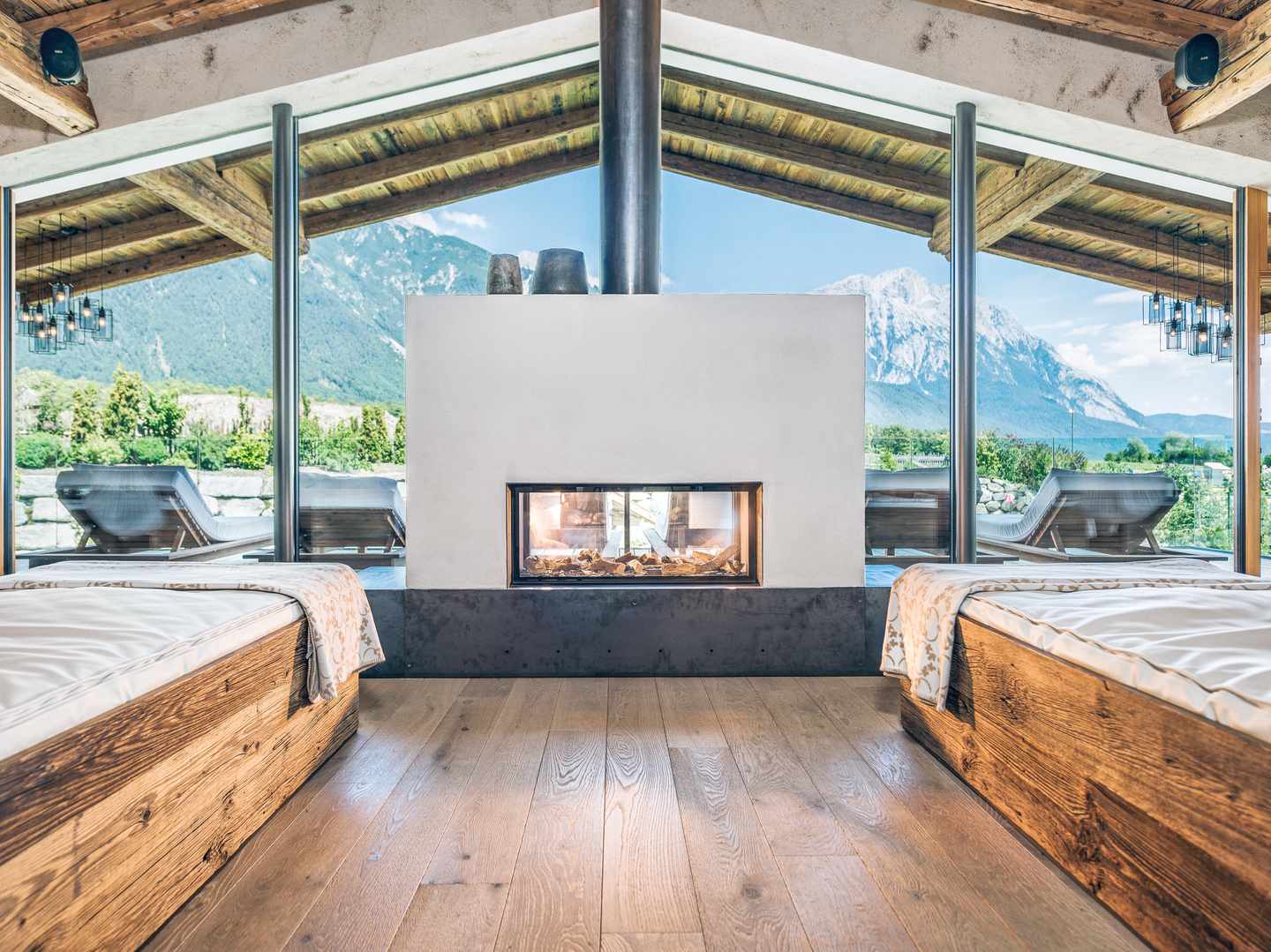 Ruheraum mit Kamin und freiem Blick auf die Berge – ein Ort zum Abschalten zwischen Sauna und Spa Ruheraum mit Kamin und Panoramablick auf die Tiroler Berge im Alpenresort Schwarz in Mieming