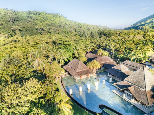 Luftbild des Hotels mit großem Pool umgeben von dichtem Wald