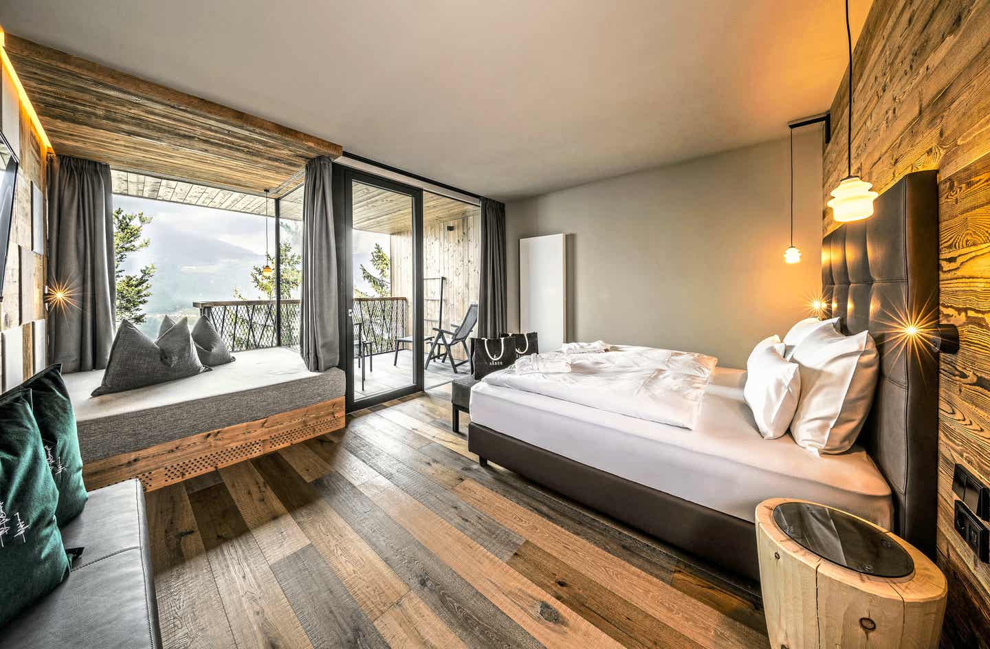 Modernes Doppelzimmer im My Arbor Hotel in Südtirol mit Holzboden, Lounge-Ecke und Panoramabalkon Die Zimmer im My Arbor kombinieren alpinen Stil mit Ausblick auf das Eisacktal