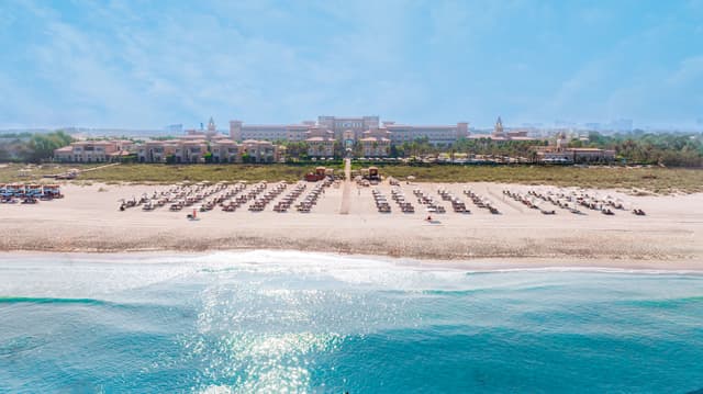 Außenansicht des Rixos Premium Saadiyat Island mit Strandzugang über einen Steg