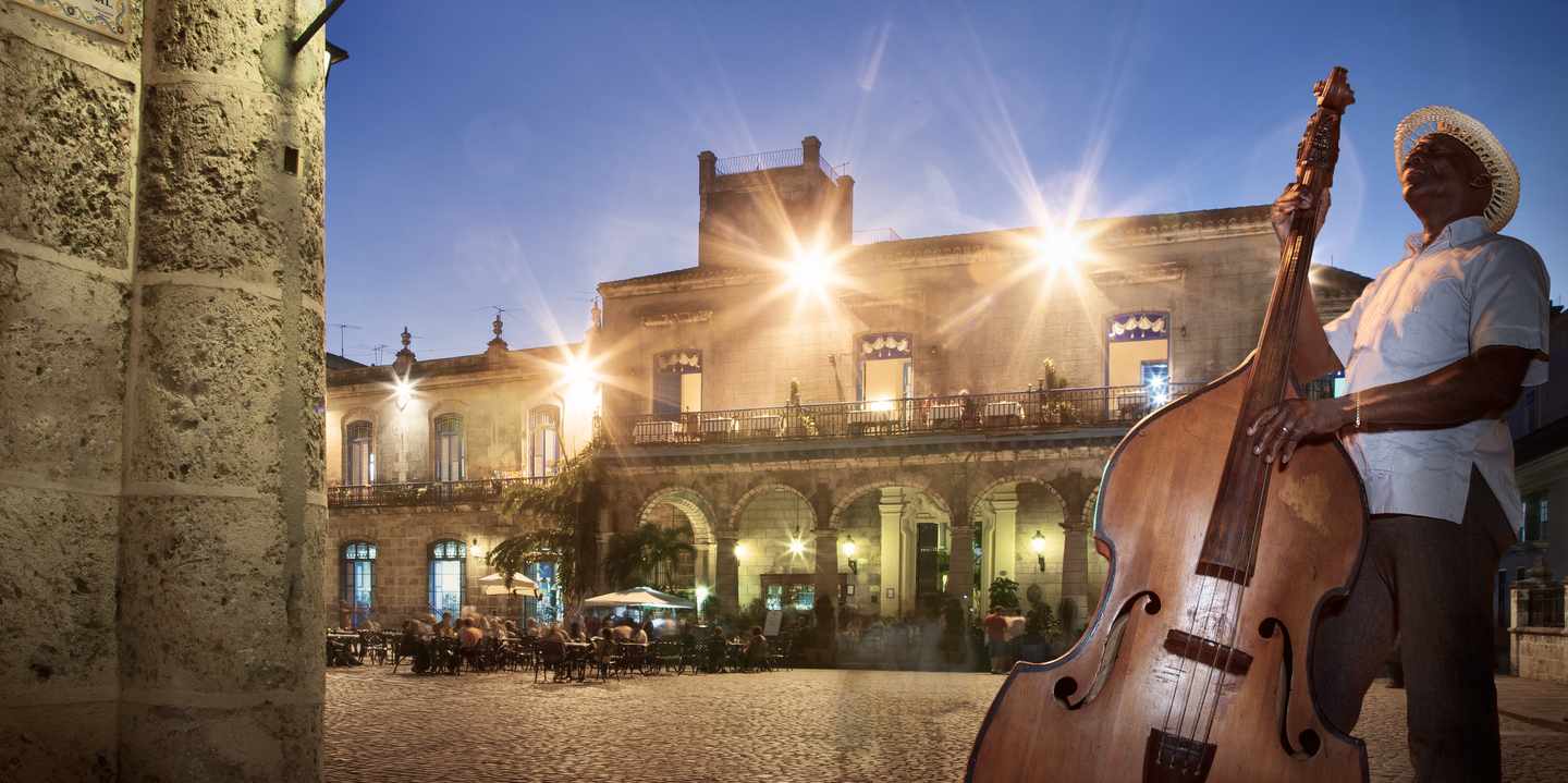 Ein mann mit einem großen Bass spielt Musik in der Altstadt von Havanna auf Kuba