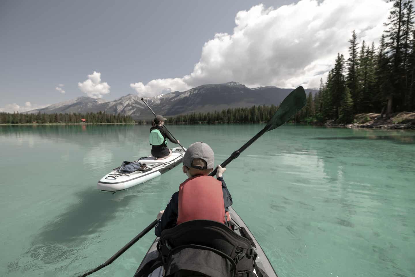 Alberta Urlaub mit DERTOUR. Mutter und Sohn paddeln über türkisgrünen Edith Lake im Jasper Nationalpark in Alberta