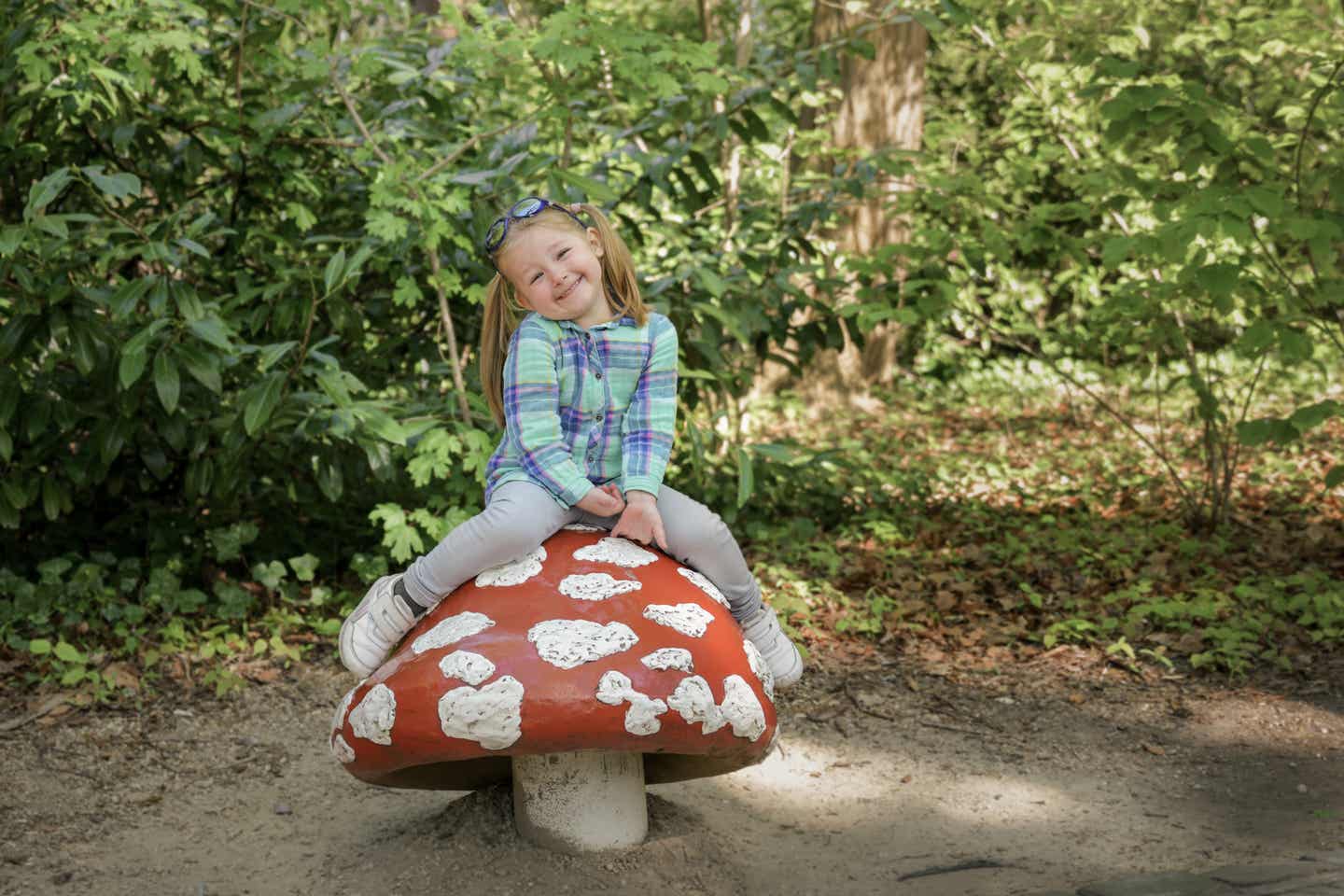 Niederlande Urlaub mit DERTOUR. Mädchen auf einem Fliegenpilz im Märchenpark Eftelingen