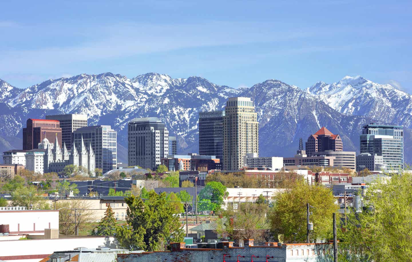 Blick auf Salt Lake City im Utah Urlaub mit Hochäusern und verschneiten Bergen im Hintergrund