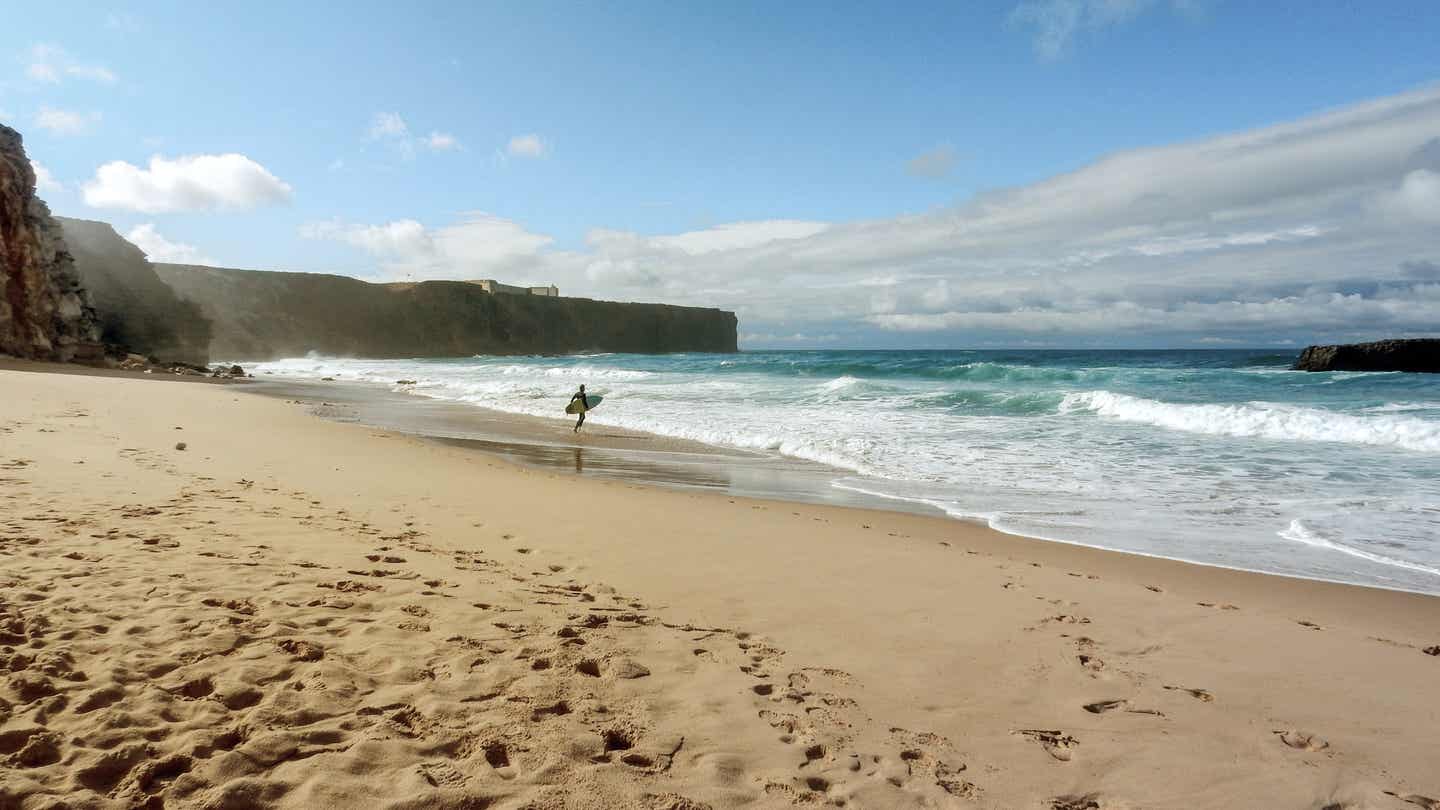 Reiseziele Ostern: Surfer am Strand in Portugal, Algarve