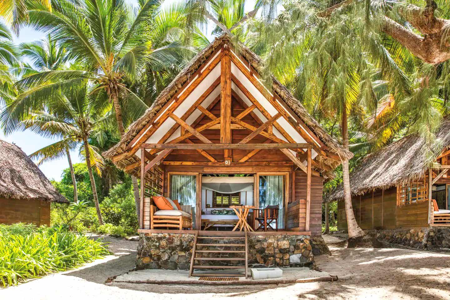 Bungalow im Constance Tsarabanjina auf Madagaskar mit Holzveranda, Palmenkulisse und direkter Strandlage auf der Insel Tsarabanjina