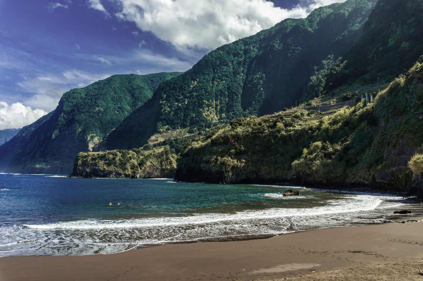 Madeiras Strand Cais do Seixal mit hohen grünen Bergen im Hintergrund