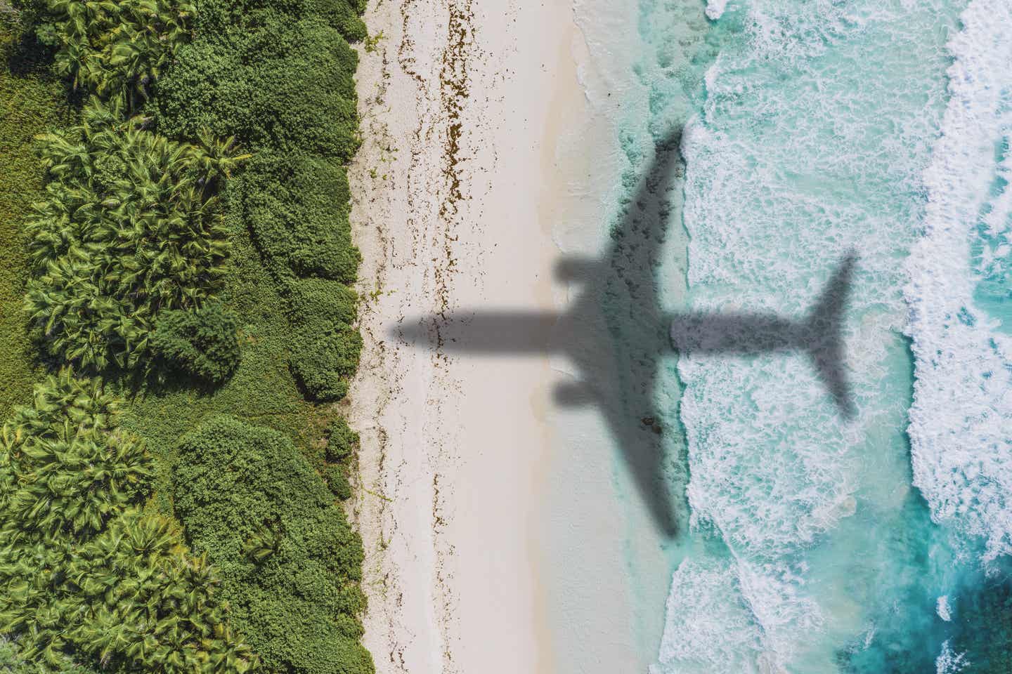 Schatten eines Flugzeugs auf dem Strand