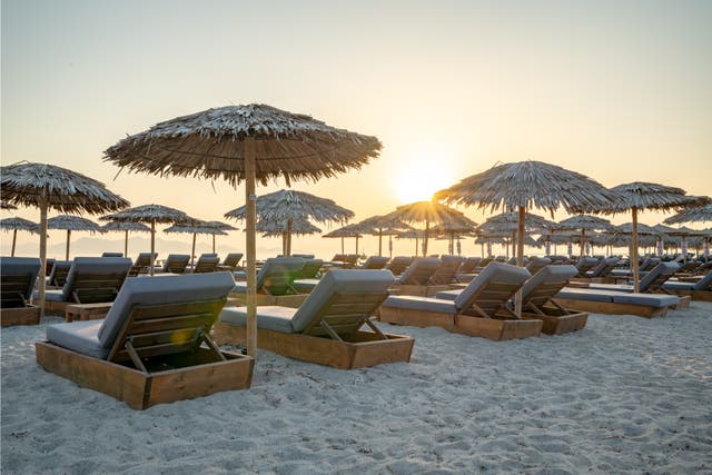 Sonnenaufgang am Strand mit Liegestühlen im Vordergrund