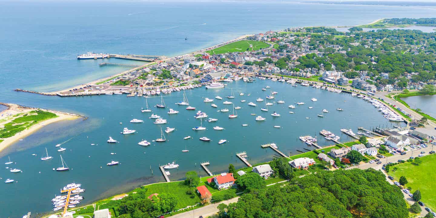 Eine Bucht mit Strand und Hafen, viele Boote im Wasser 