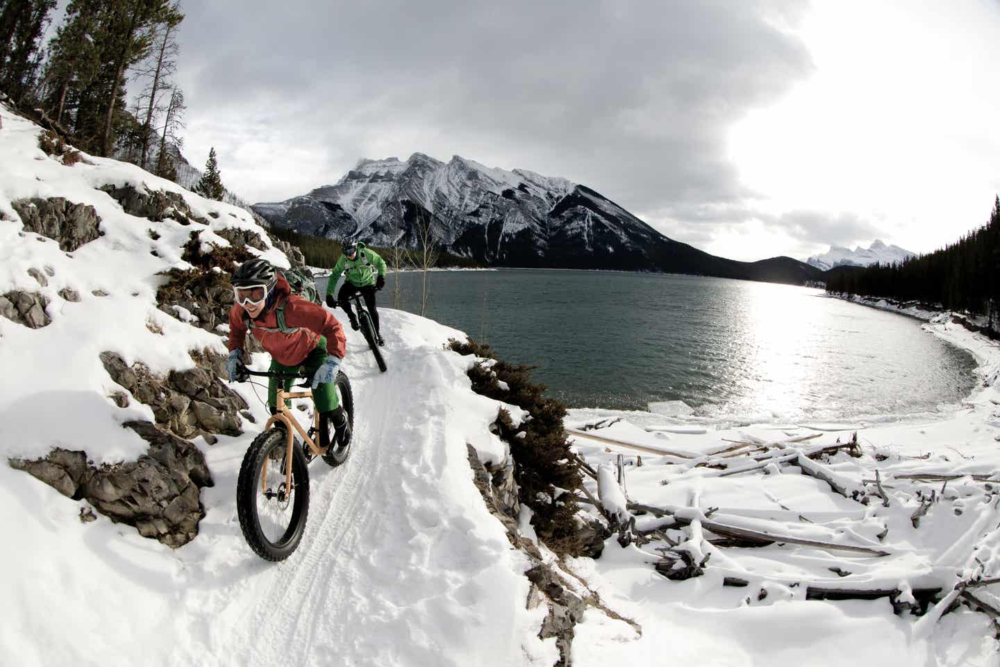 Alberta Urlaub mit DERTOUR. Paar auf Mountainbikes im verschneiten Banff Nationalpark