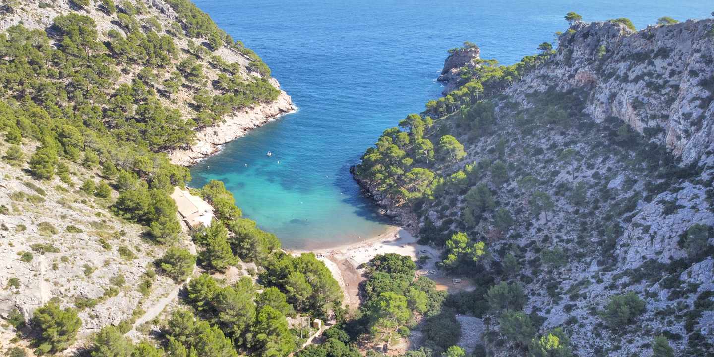 Cala Murta auf Mallorca aus der Luft mit türkisblauer Bucht, Kiesstrand und bewaldeten Felshängen nahe Formentor