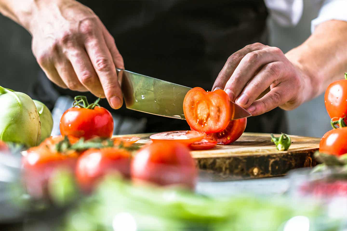 Koch schneidet Tomaten auf Mallorca