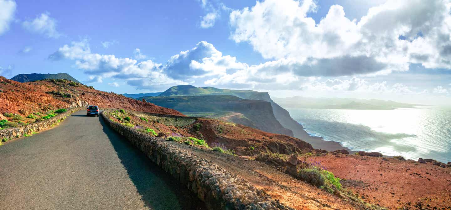 Küstenstraße auf Lanzarote mit Blick auf das Meer, Vulkane und dramatische Landschaften