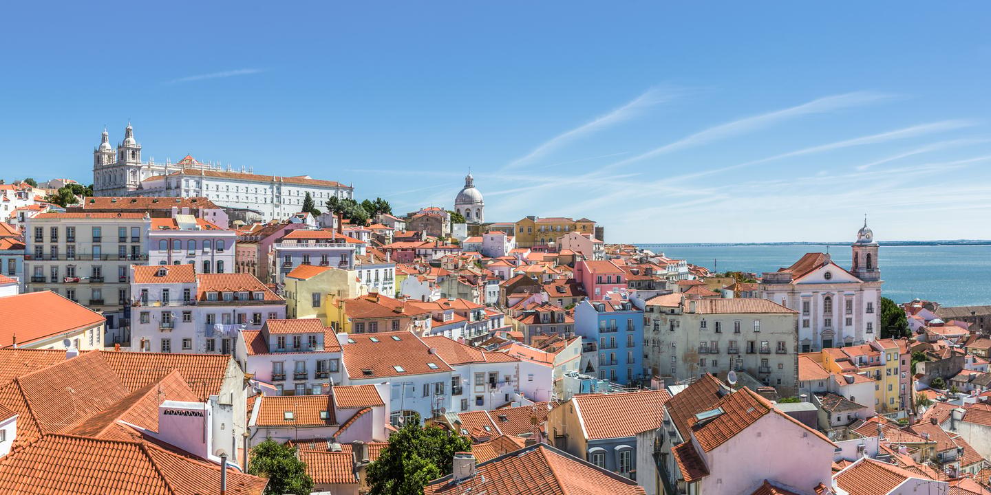 Blick über Lissabons Altstadt Alfama mit dem Tejo im Hintergrund – eine der schönsten Sehenswürdigkeiten der Stadt