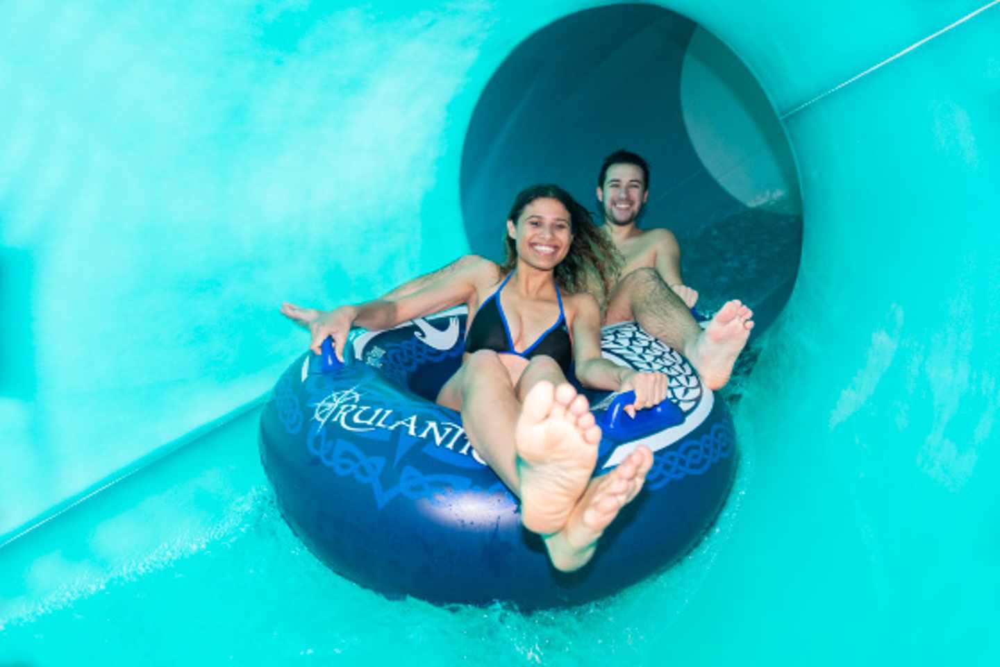 Paar saust auf Reifen die Wasserrutsche Stormvind in der Wasserwelt Rulantica hinunter.