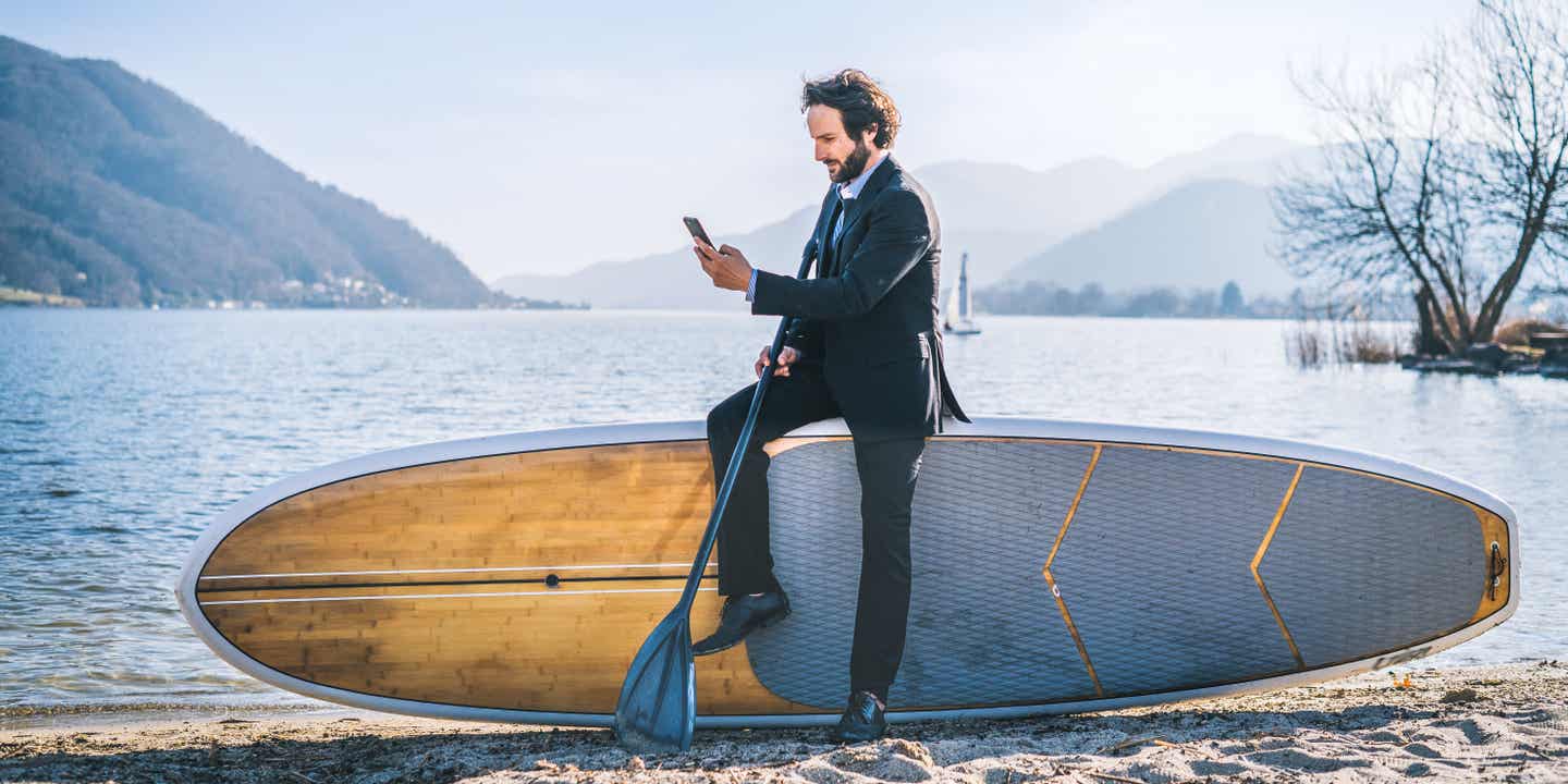 Geschäftsmann am See mit SUP im Anzug