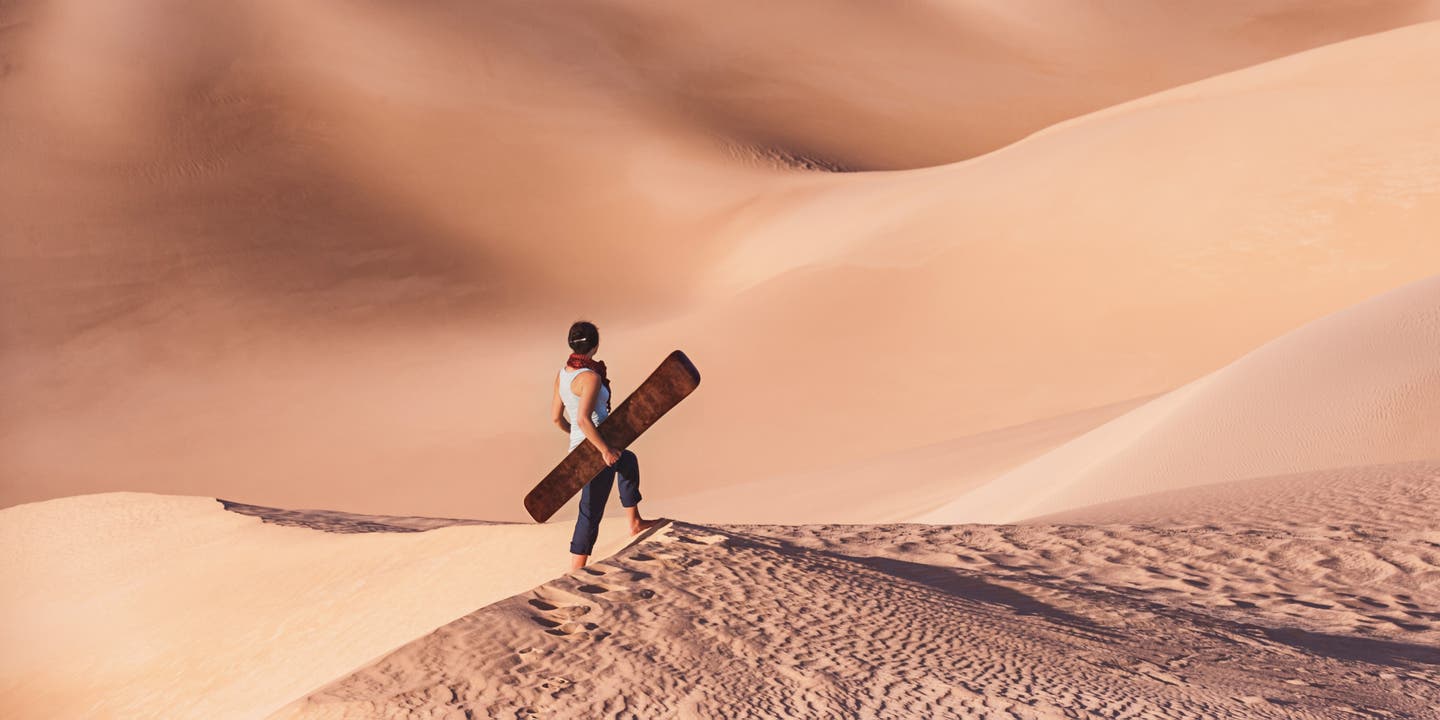 Dubai Frau mit Sandboard in der Wüste