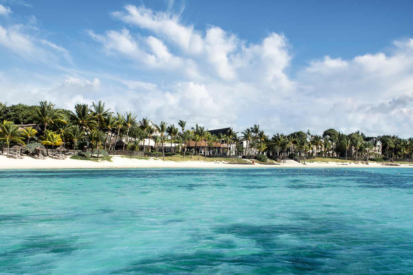 Mauritius´ Belle Mare Beach mit saftig grünen Palmen vom glasklaren Wasser aus aufgenommen