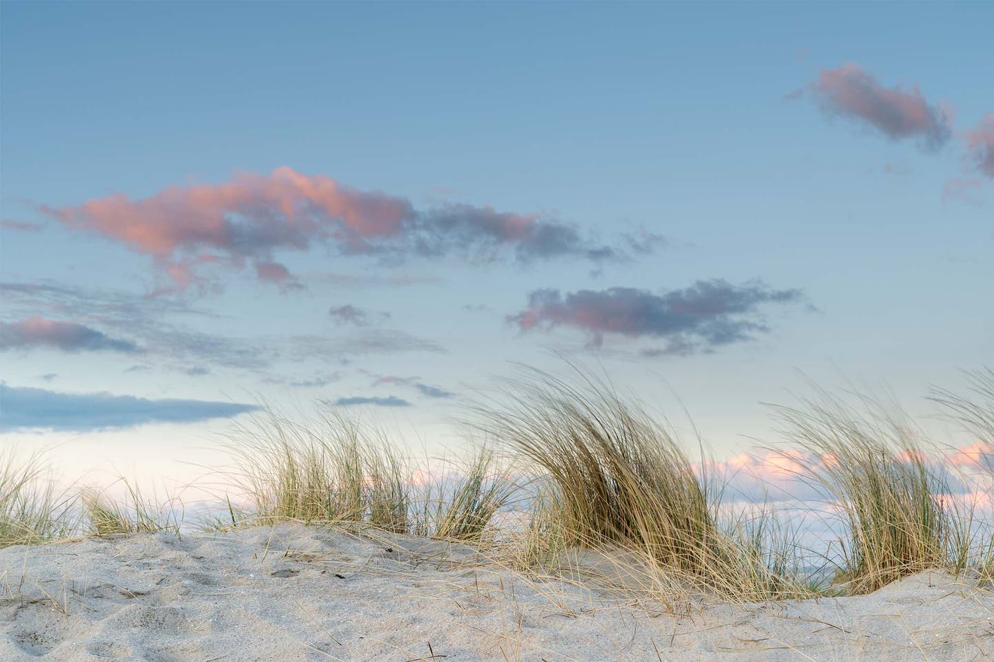 Sanddünen und rosa Wolken am Himmel an der Nordsee