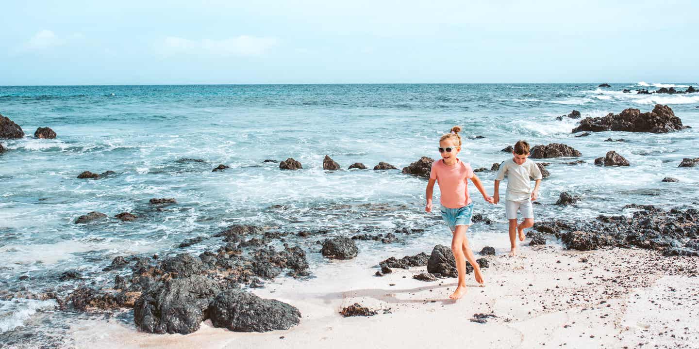 Familienurlaub auf den Kanaren: Zwei Kinder spielen an einem Strand auf Lanzarote