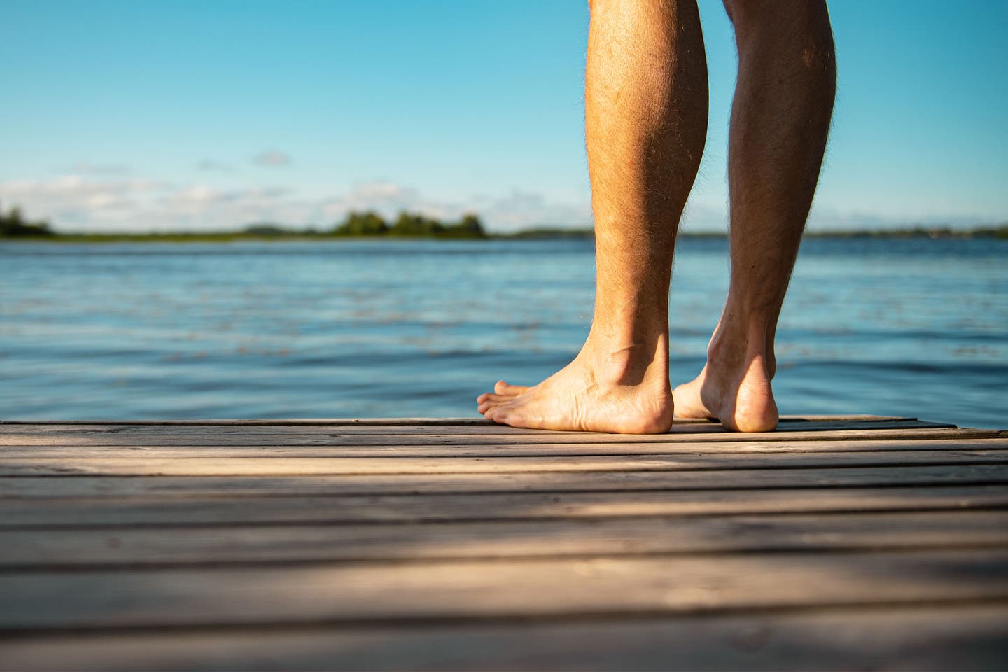 Füße eines Badeurlaubers am Steg des Bodensees