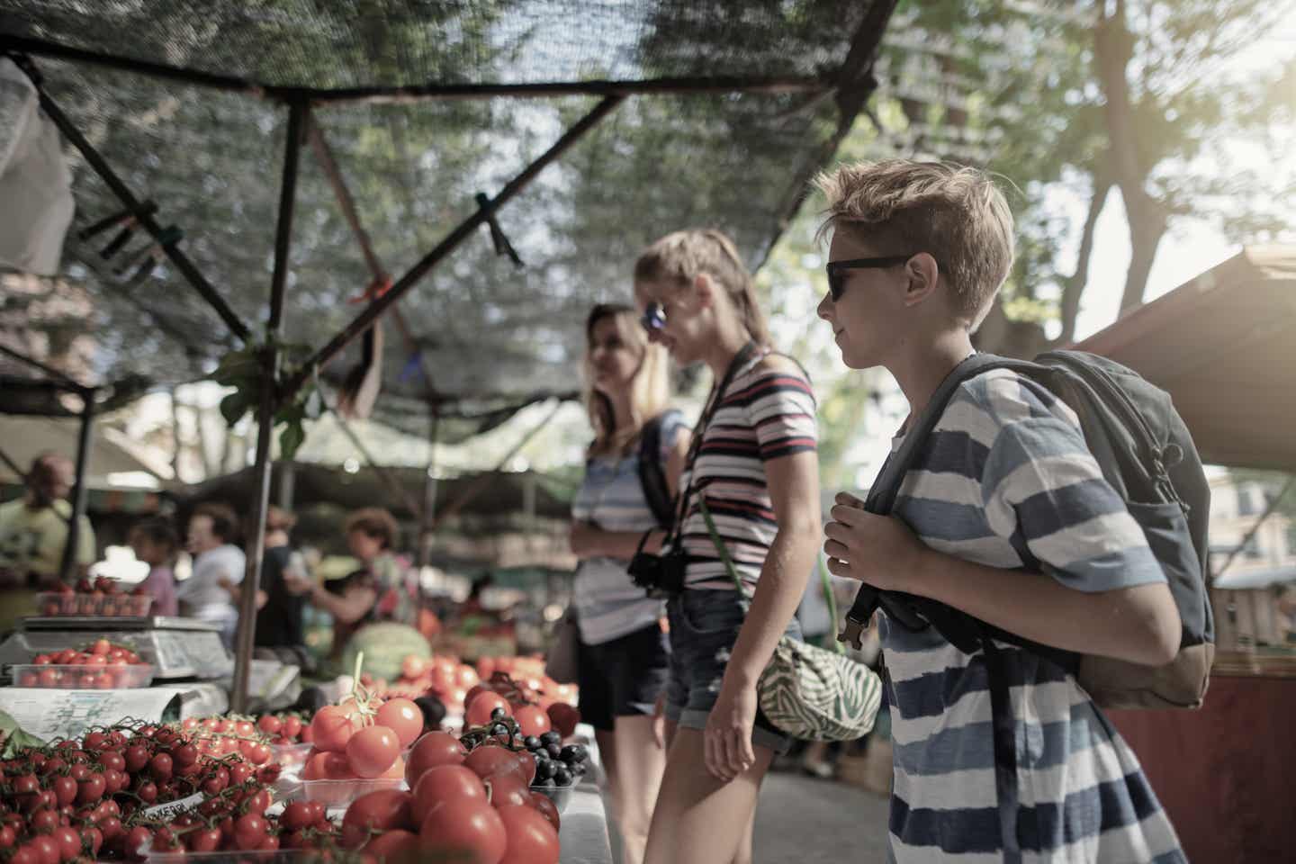 Ibiza Urlaub mit DERTOUR. Mutter mit Sohn und Tochter bei einem Marktbesuch auf Ibiza