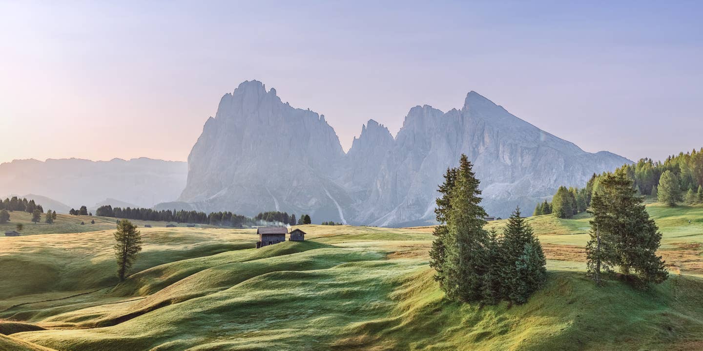 Südtirol Urlaub mit DERTOUR. Alpe die Siusi in Südtirol. Blick auf das Langkofel-Bergmassiv bei Sonnenaufgang