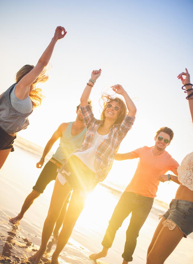 Zu den Angeboten Urlaub am Strand - Junge Leute machen Party