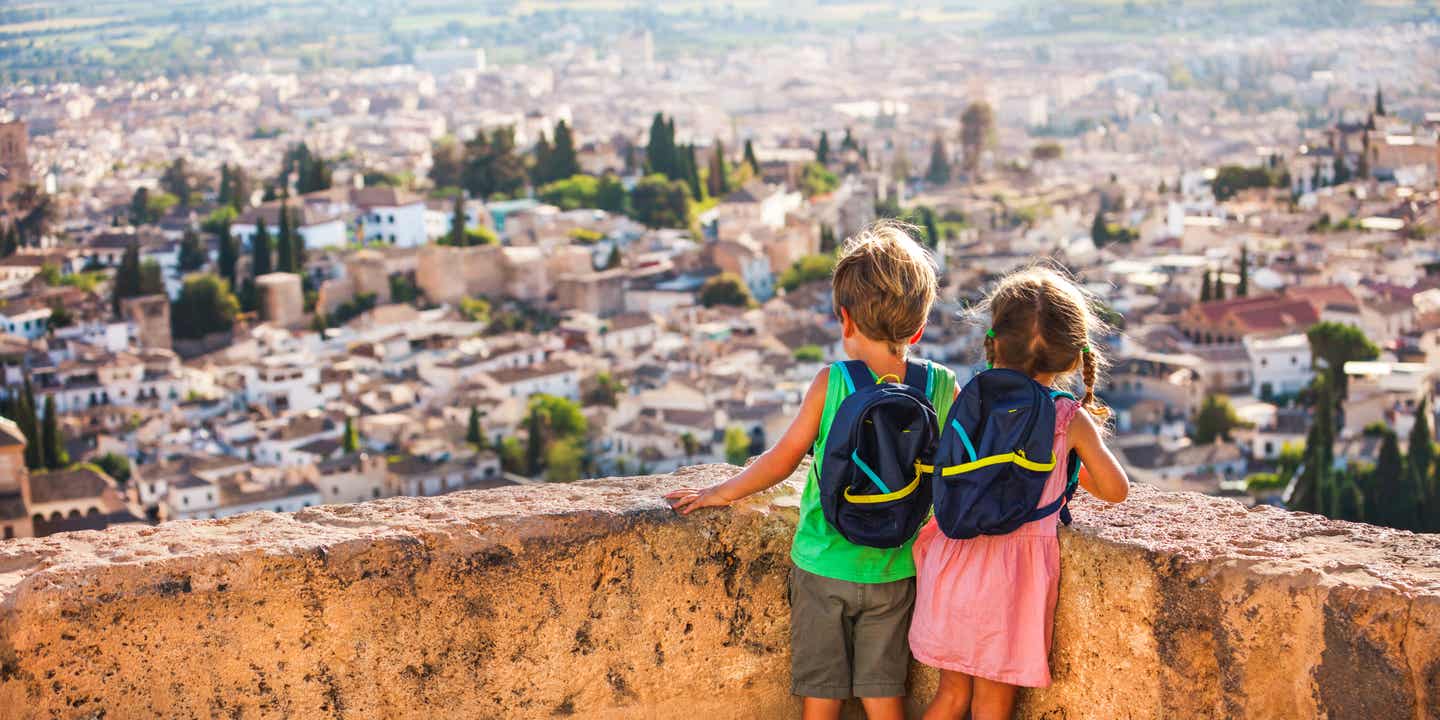 Andalusien als Urlaubsziel: zwei Kinder schauen über die Häuser von Granada