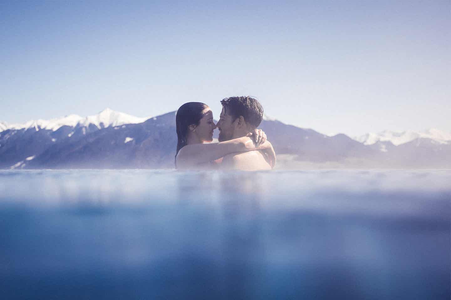 Paar im Infinity-Pool in Südtirol vor Bergpanorama