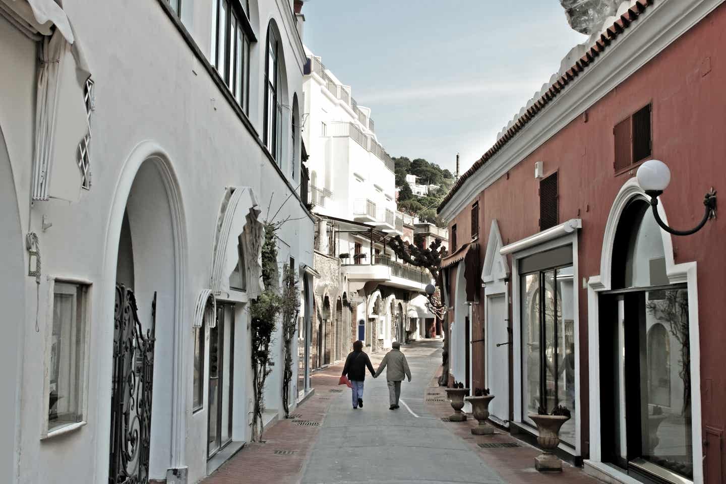 Capri Urlaub mit DERTOUR. Paar spaziert Hand in Hand durch die Straßen einer Stadt auf Capri