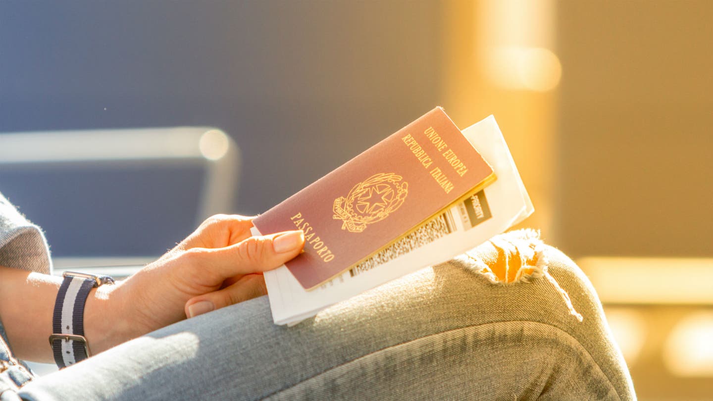 Frau mit Reisepass und Bordkarte sitzt am Flughafen