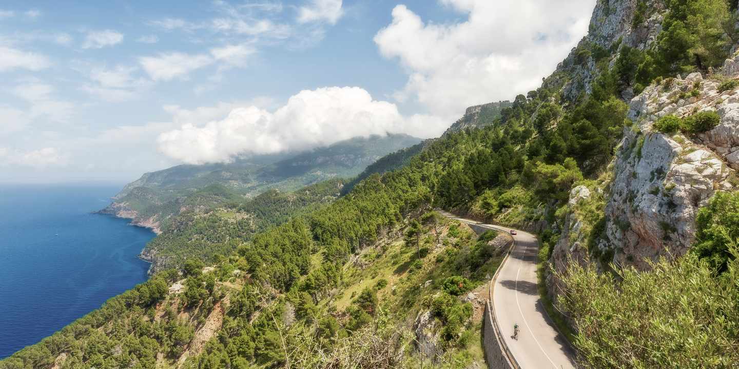 Eine Straße schlängelt sich zwischen Küste und Tramuntana-Gebirge im Westen Mallorcas