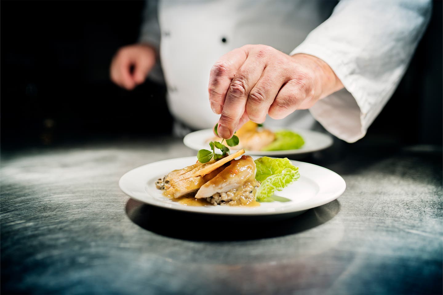 Chefkoch richtet Essen auf einem Teller an