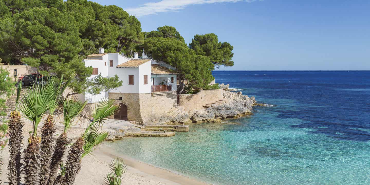 Eine charmante kleine Bucht mit flachem Wasser und einer weißen Finca auf einem Felsen