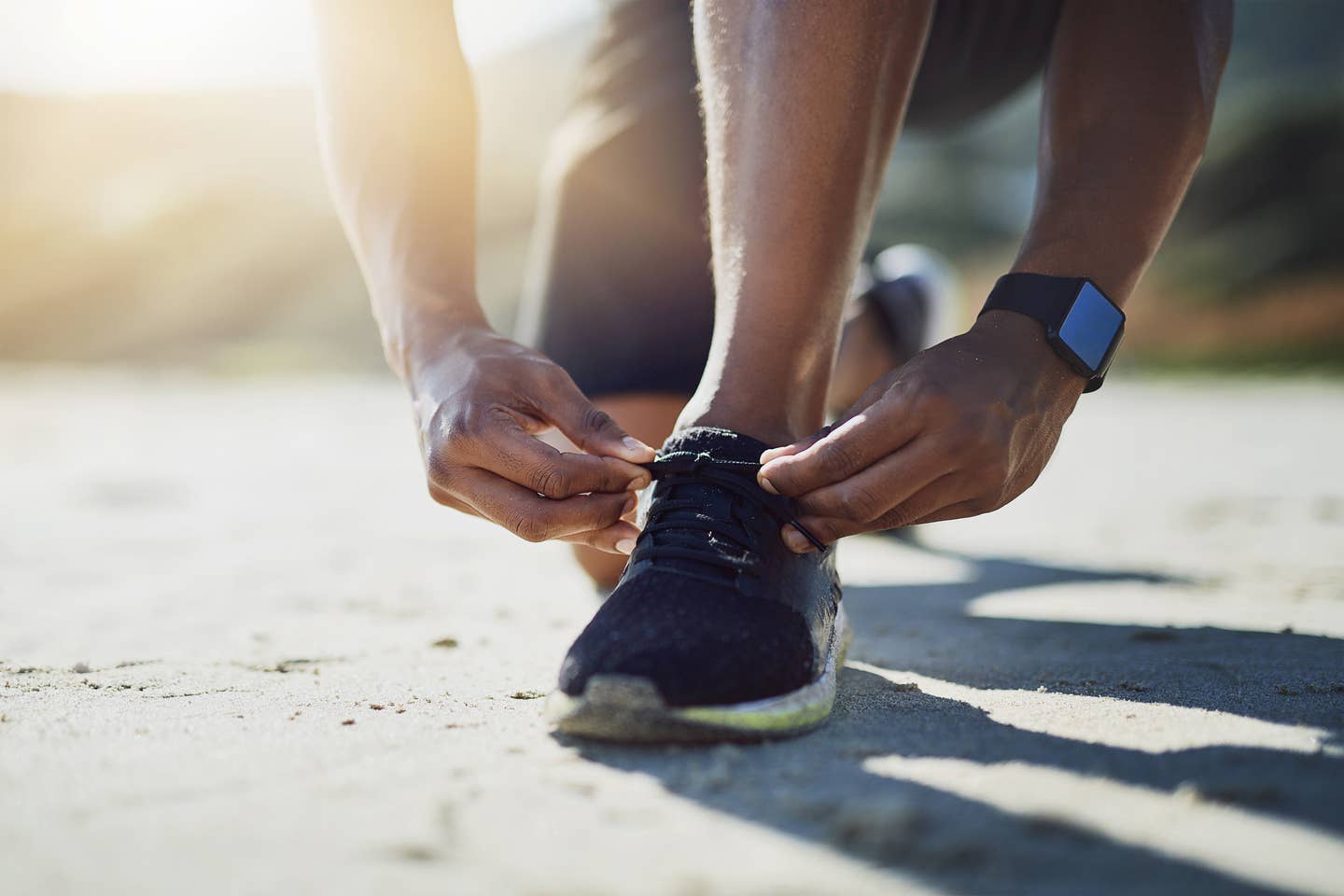 Sportler bindet sich die Schuhe auf einer Trainingsreise