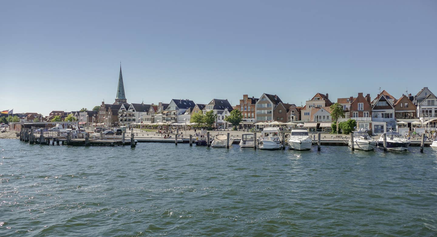 Travemünde Urlaub mit DERTOUR. Promenade Travemündes vom Wasser aus fotografiert mit Booten davor