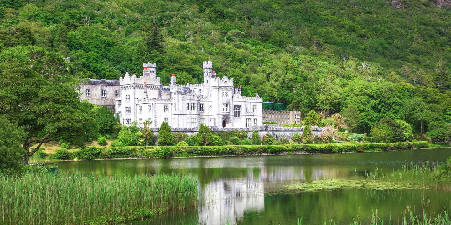 Kylemore Abbey im Connemara Nationalpark am See, umgeben von Wäldern und Bergen in Irland 