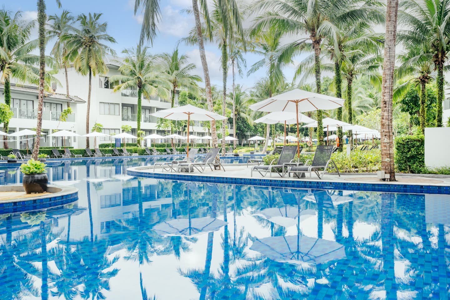 Sonnenliegen und -schirme rund um die Poollandschaft des X10 Khaolak Resorts