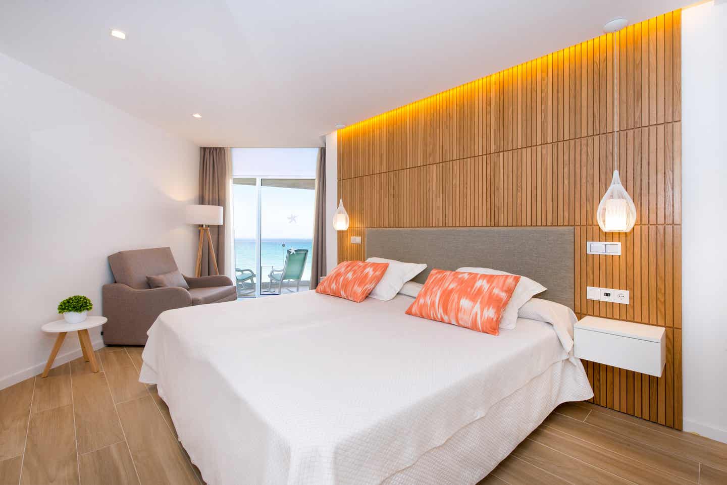 Beste Familienhotels Mallorca – Modernes Zimmer im Iberostar Selection Playa de Muro Village mit Meerblick, stilvollem Holzdesign und eleganter Einrichtung