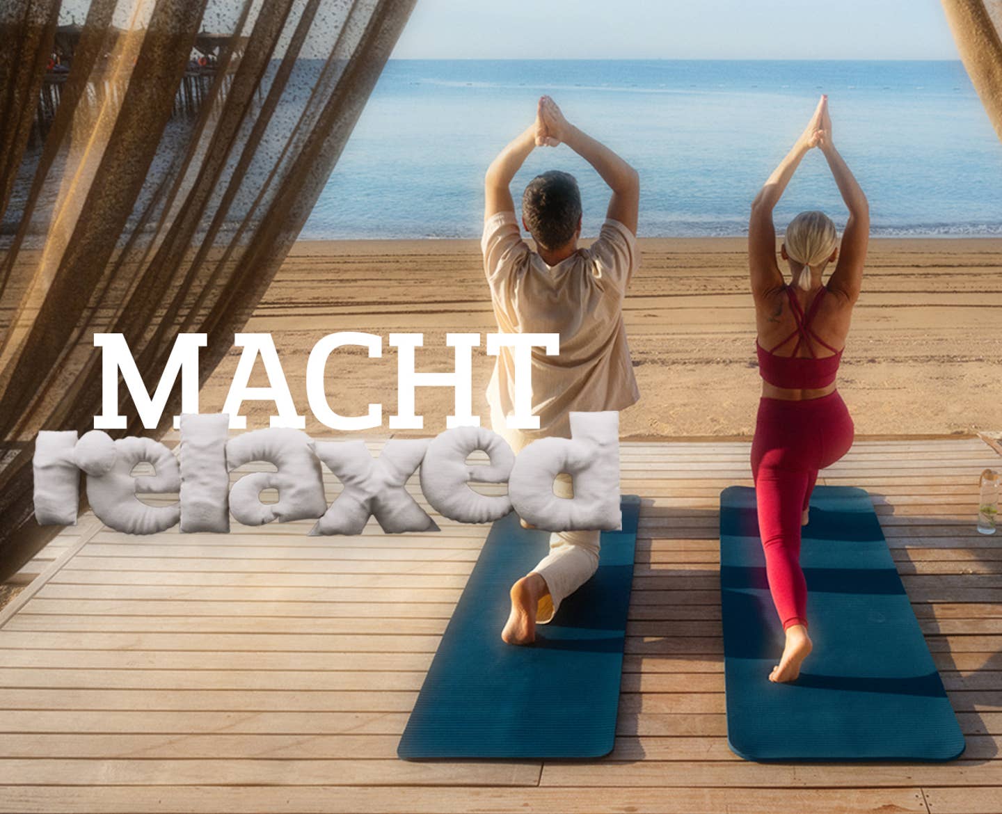 Macht Relaxed: Paar macht Yoga am Strand mit Blick auf das Meer