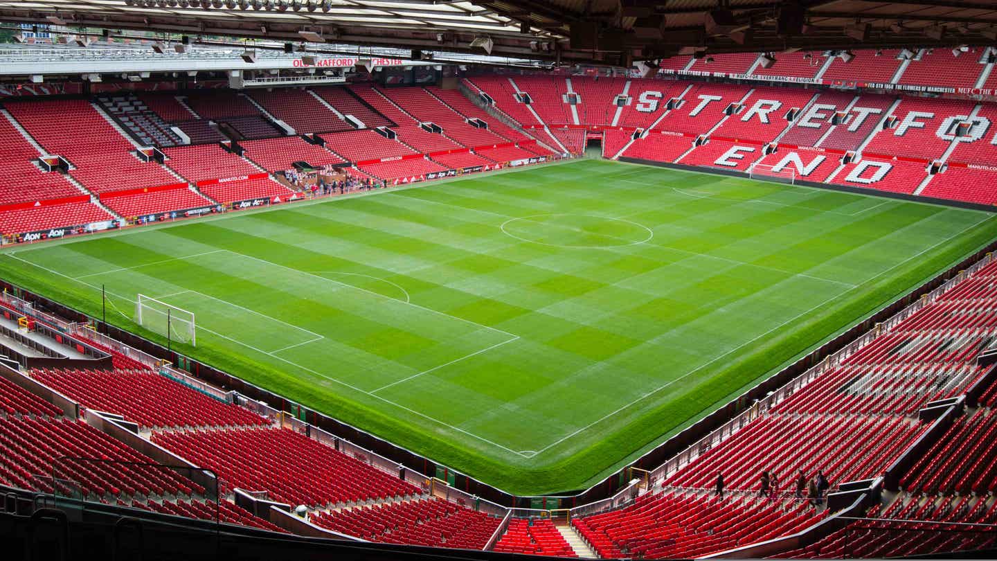 Manchester United Tickets Hotel Reisepakete. Blick von Tribüne auf den Rasen des Old Trafford Stadions.