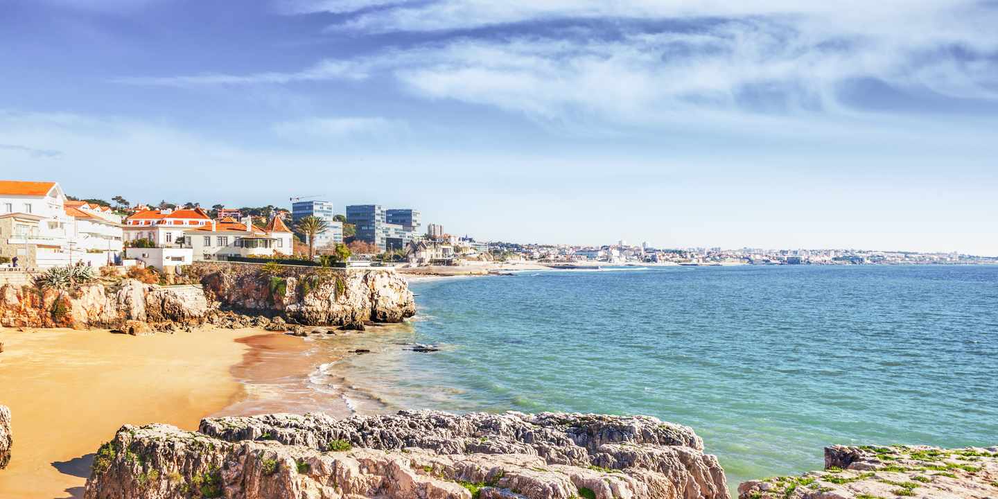 Küstenlinie von Cascais mit Felsen, Sandstrand und Blick auf Stadt und Atlantik