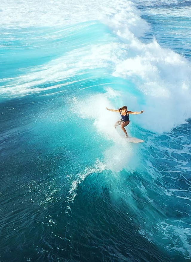 Auf Fuerteventura surfen: alle Top-Tipps Surferin auf dem blauen Ozean vor Fuerteventura