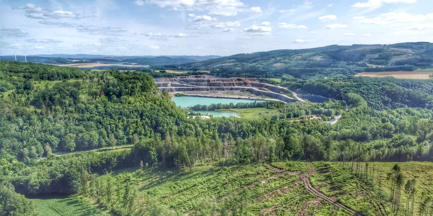 Luftaufnahme der Blauen Lagune bei Balve-Eisborn im Sauerland mit türkisfarbenem Wasser und Wäldern