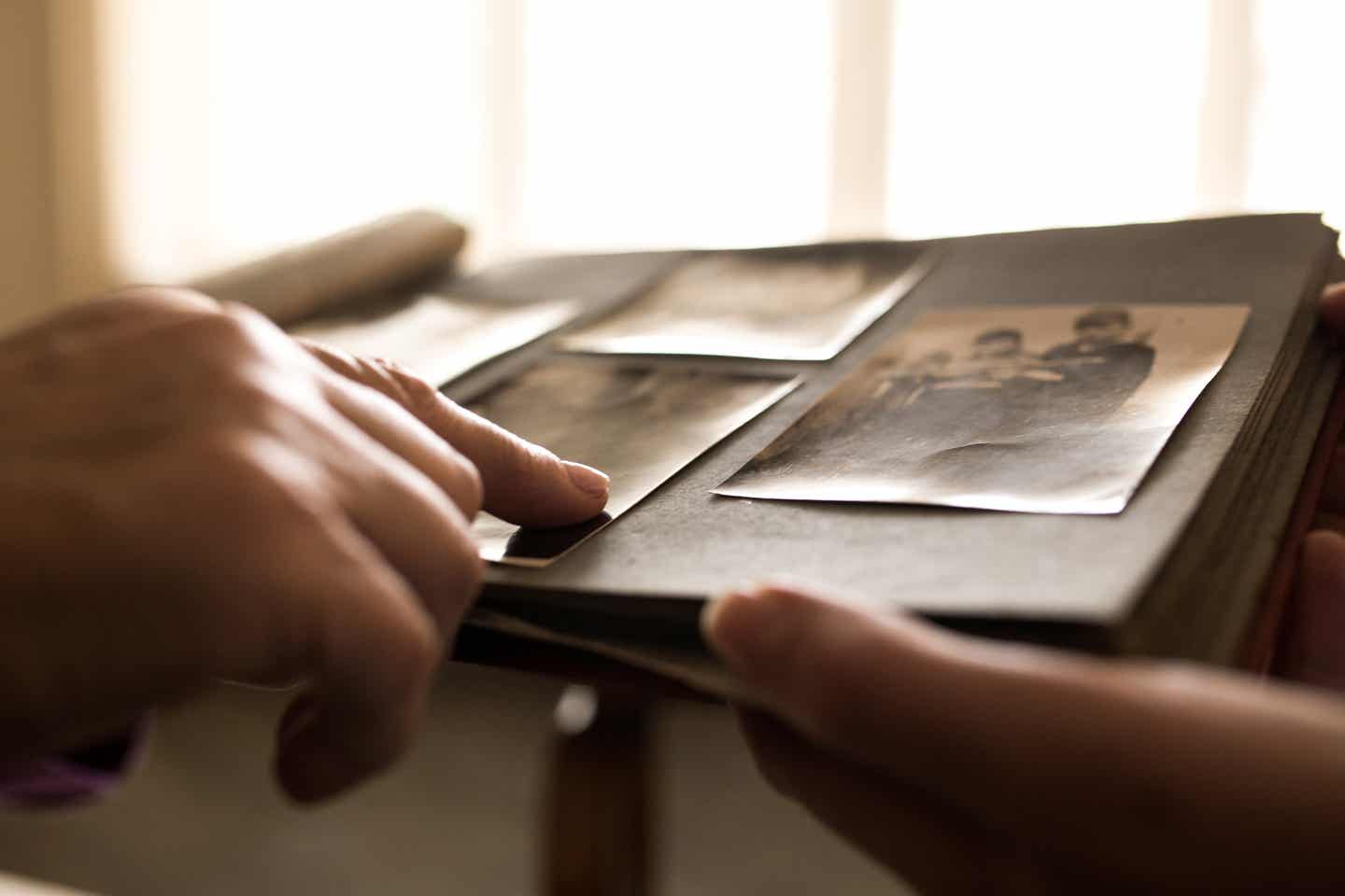 Nahaufnahme: Menschenhand auf Fotoalbum