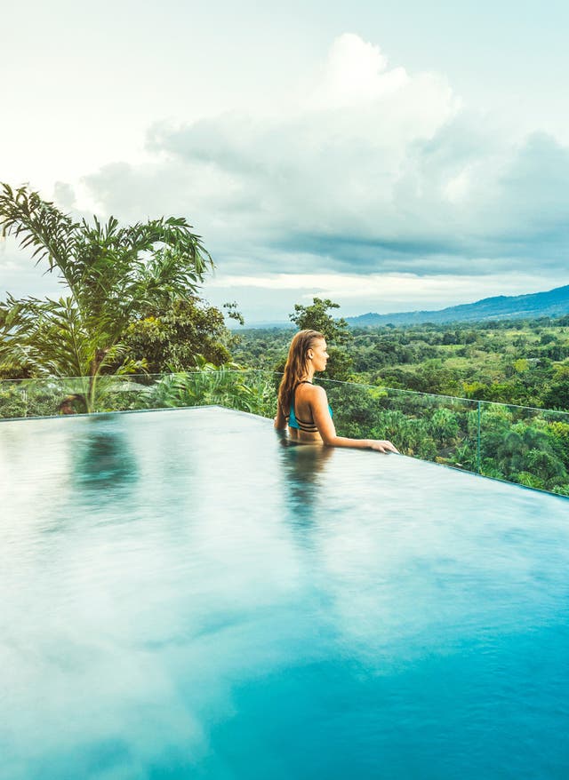 Jetzt entdecken Costa Rica: Frau im Infnity Pool schaut in die Ferne