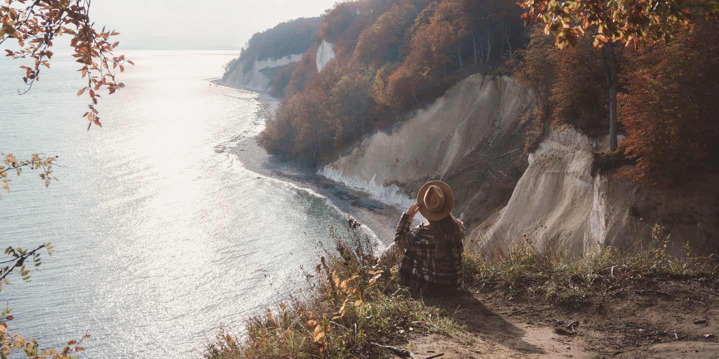 Nachhaltigkeit Frau auf Klippe mit Aussicht auf das Meer